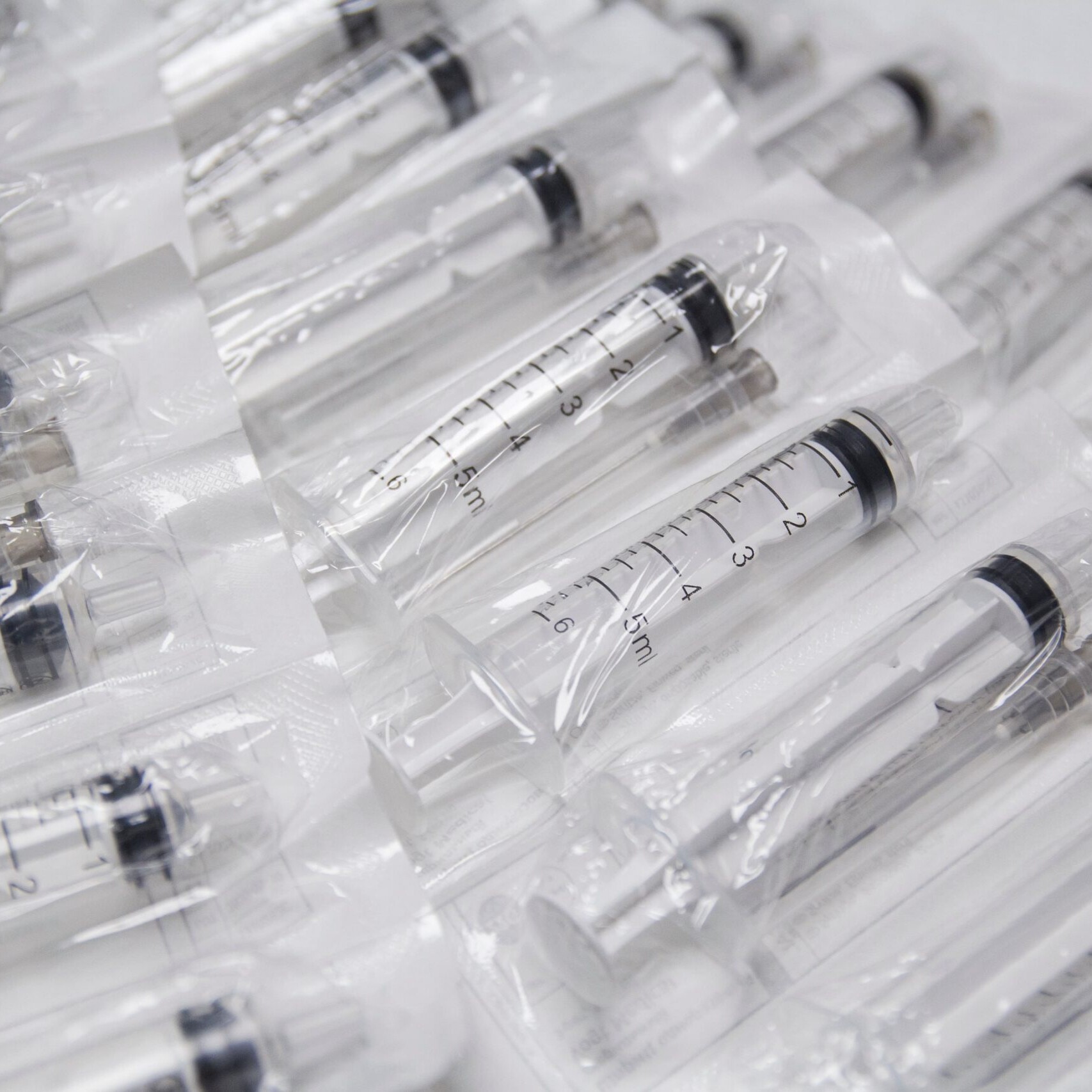 clear plastic medical syringes without needles lay flat