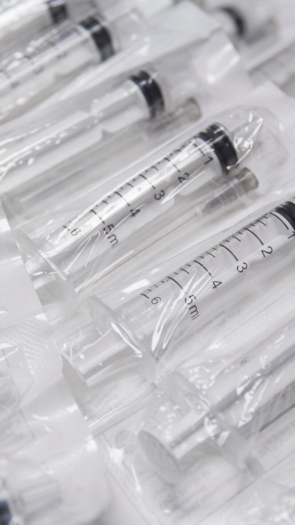 clear plastic medical syringes without needles lay flat