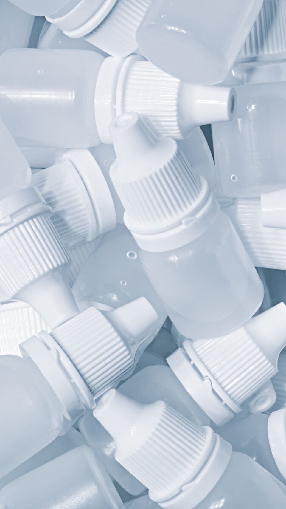White plastic medical bottles vials for medicinal nose or eye drops as a solid white textured background, medical health concept