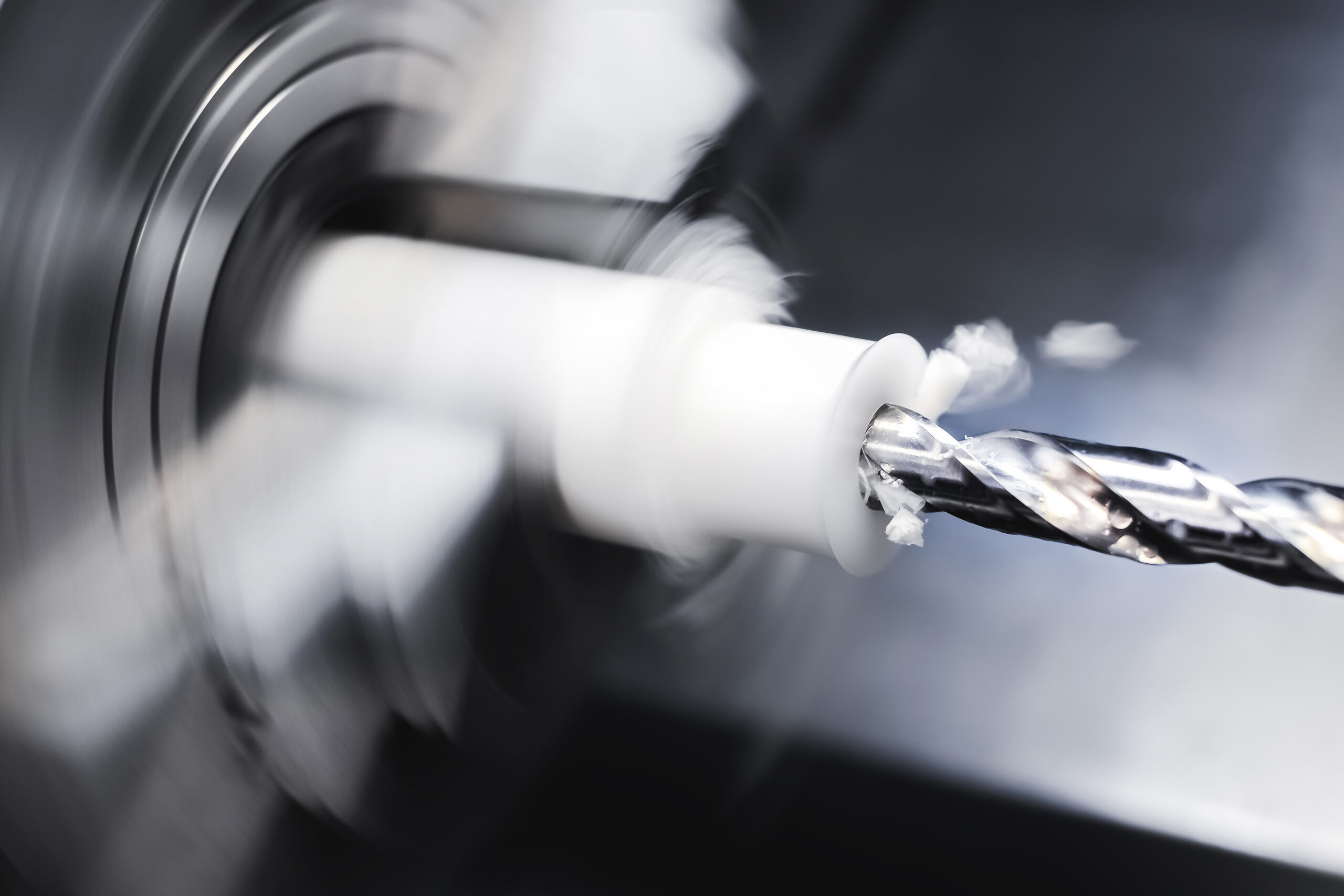Operation of a CNC lathe on a workpiece made of textolite or polyethylene or propylene. Automation of the production base. The chips are flying